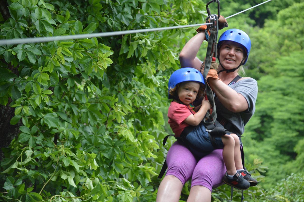 A Mom and her daughter zip-lining through the rainforest, on our kid's friendly zip lining.