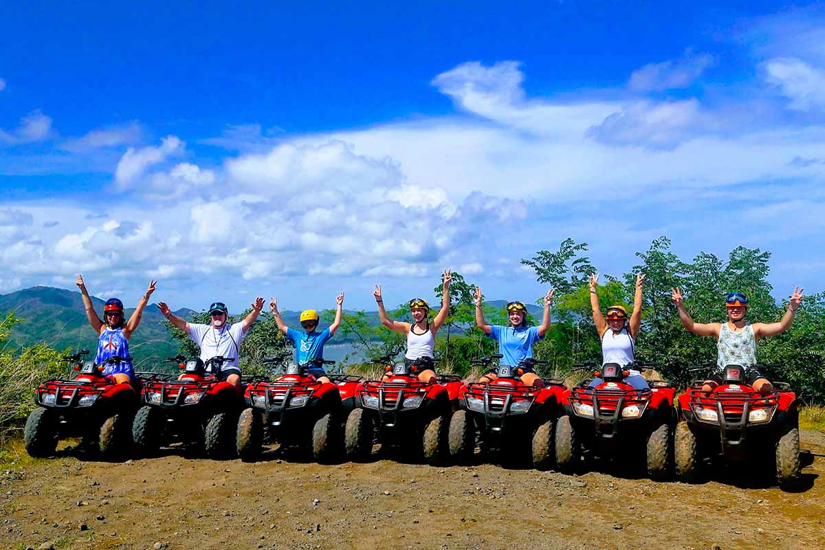 Family riding an ATV with stunning scenery in the background.